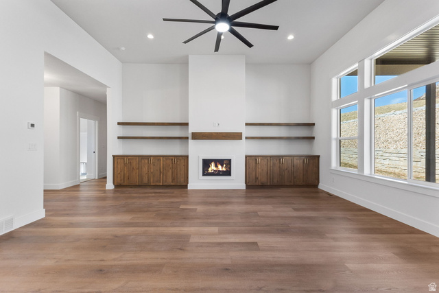 638 East Mountain Road North Ogden, UT 84414 - Photo 10 of 28 Unfurnished living room with a glass covered fireplace, dark wood-style floors, recessed lighting, and a ceiling fan