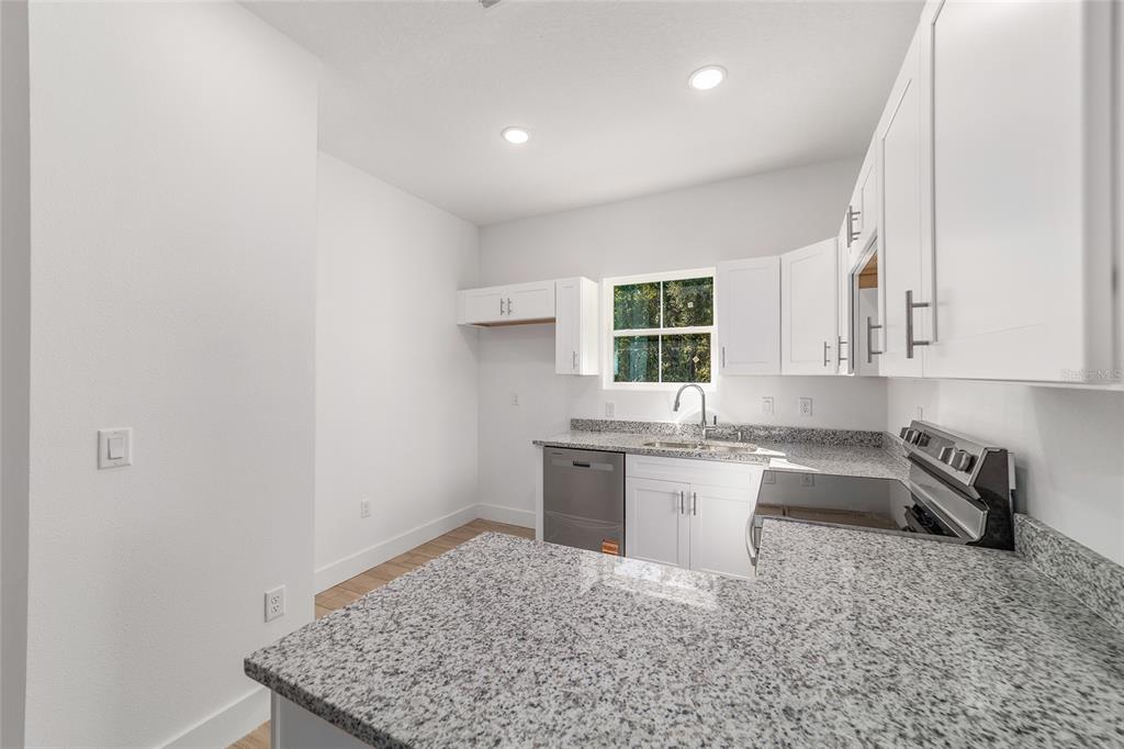 15431 Southwest 41st Street Road Ocala, FL 34481 - Photo 13 of 44 a kitchen with a sink stove and cabinets
