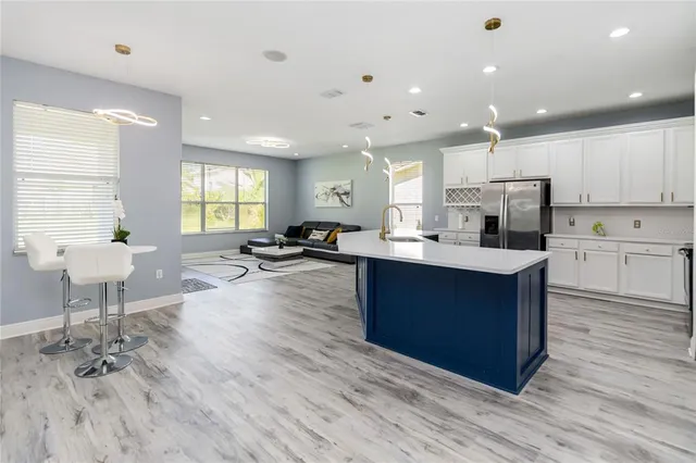 a kitchen with kitchen island a sink stainless steel appliances and cabinets