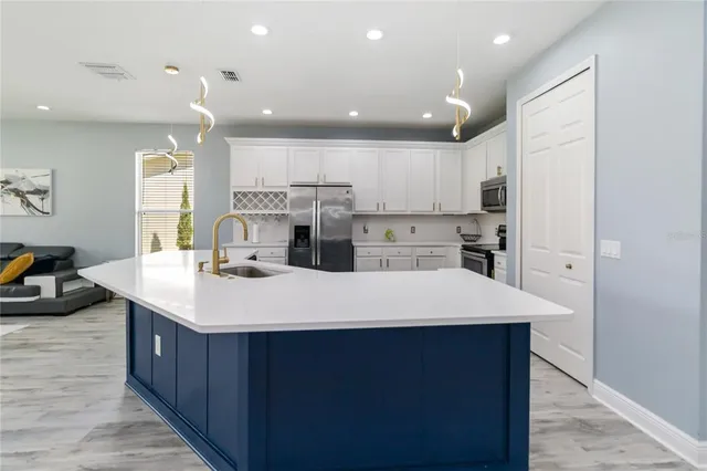a large kitchen with kitchen island a sink stainless steel appliances and cabinets