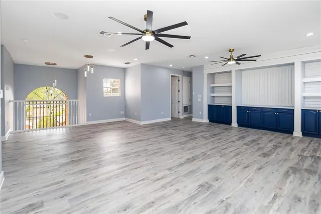 a view of a livingroom with a ceiling fan and wooden floor