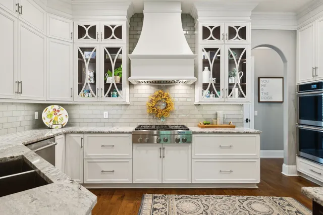 a kitchen with kitchen island granite countertop a sink and stainless steel appliances