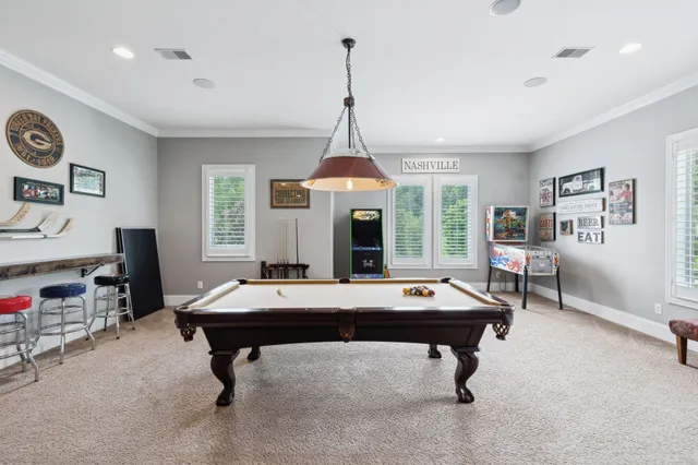 a bedroom with a bed a chandelier and a dresser