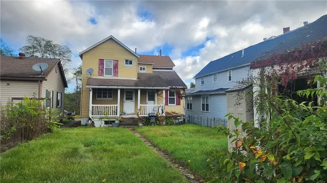 a front view of a house with a garden and plants