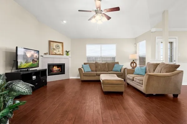 a living room with furniture a fireplace and a flat screen tv