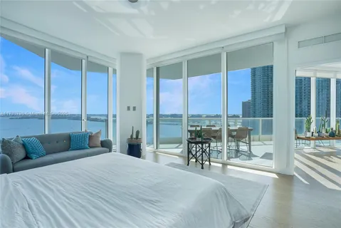 a bedroom with a bed and a large window