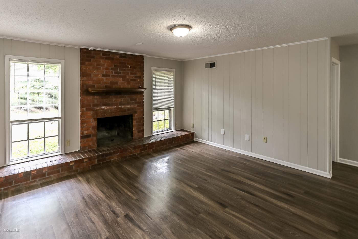 5217 Yale Road Memphis, TN 38134 - Photo 11 of 30 Unfurnished living room featuring dark wood-type flooring, crown molding, a fireplace, and a textured ceiling