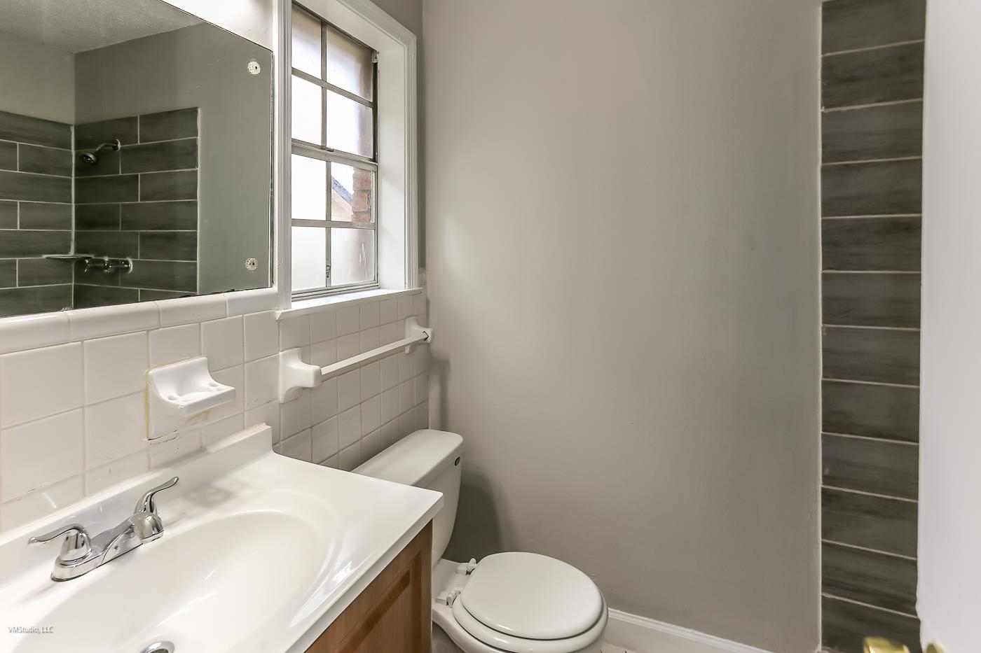 5217 Yale Road Memphis, TN 38134 - Photo 15 of 30 Bathroom with vanity, toilet, tasteful backsplash, and tile walls