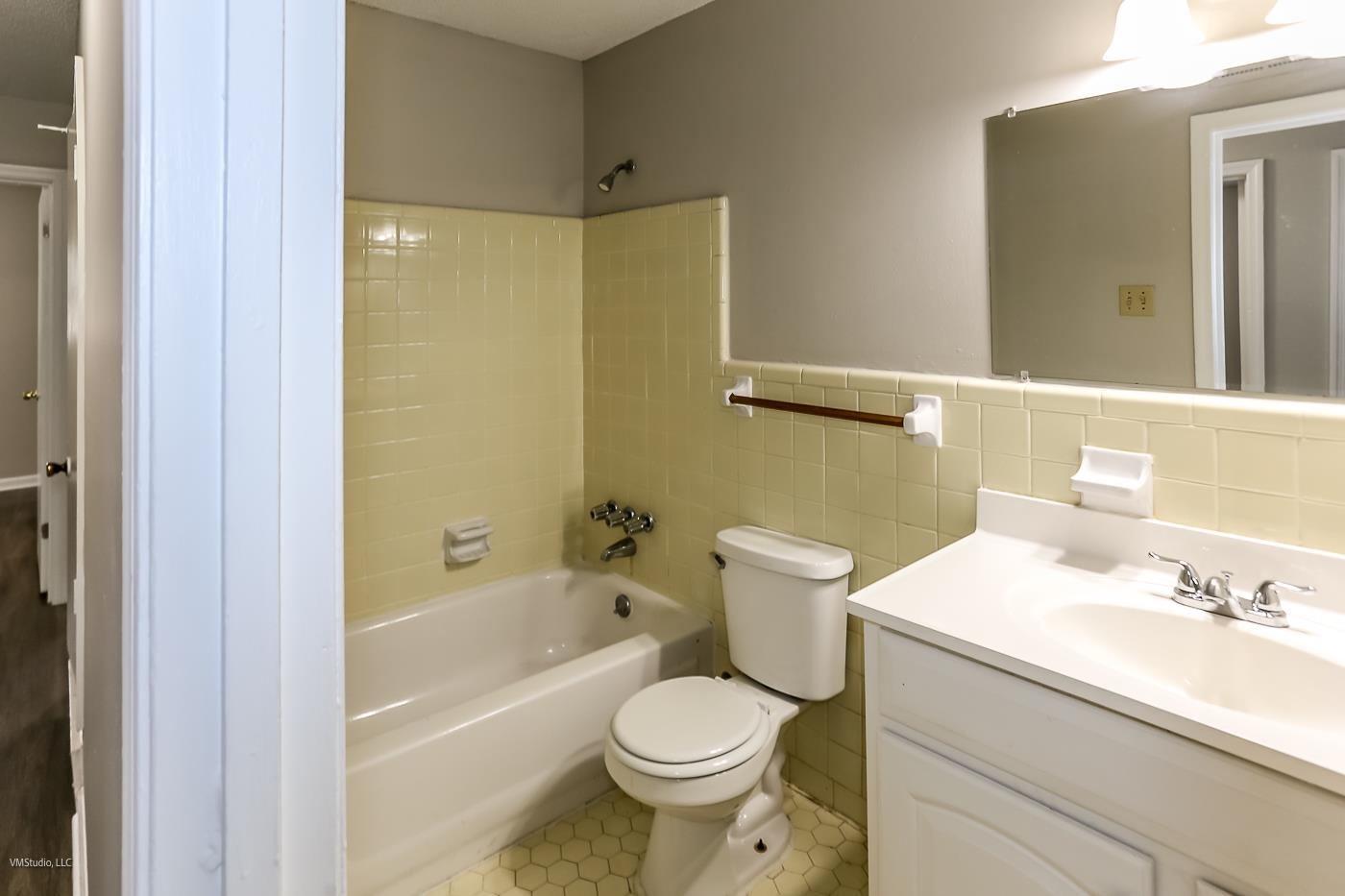 5217 Yale Road Memphis, TN 38134 - Photo 17 of 30 Full bathroom featuring tasteful backsplash, tile patterned flooring, tile walls, tiled shower / bath, and vanity