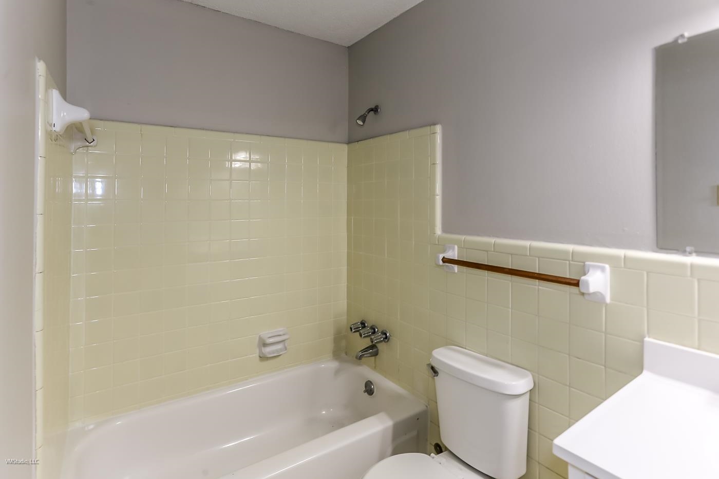 5217 Yale Road Memphis, TN 38134 - Photo 18 of 30 Bathroom featuring toilet, tiled shower / bath, and tile walls