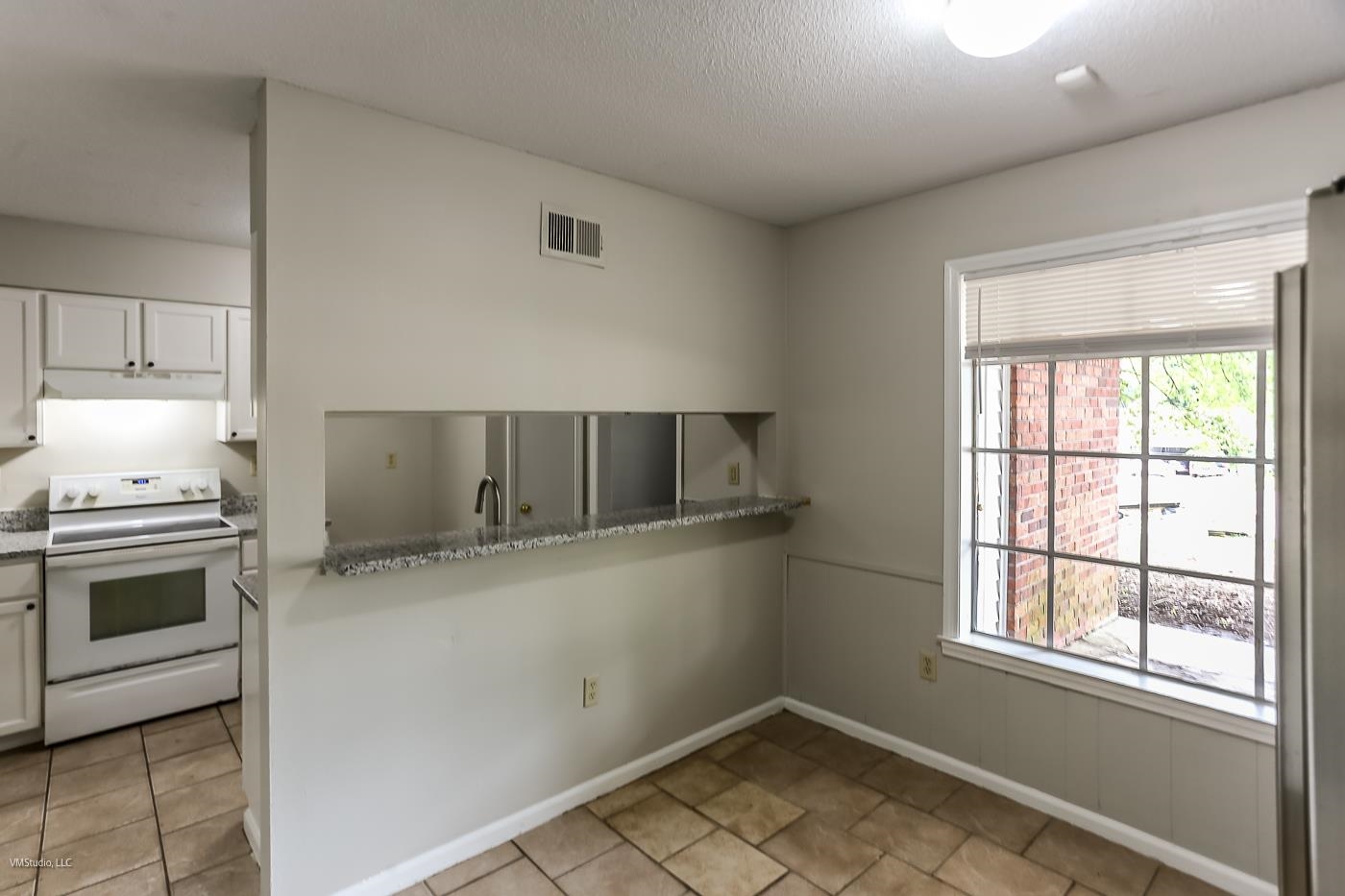 5217 Yale Road Memphis, TN 38134 - Photo 5 of 30 Kitchen featuring white cabinetry, white range with electric stovetop, and light tile patterned floors