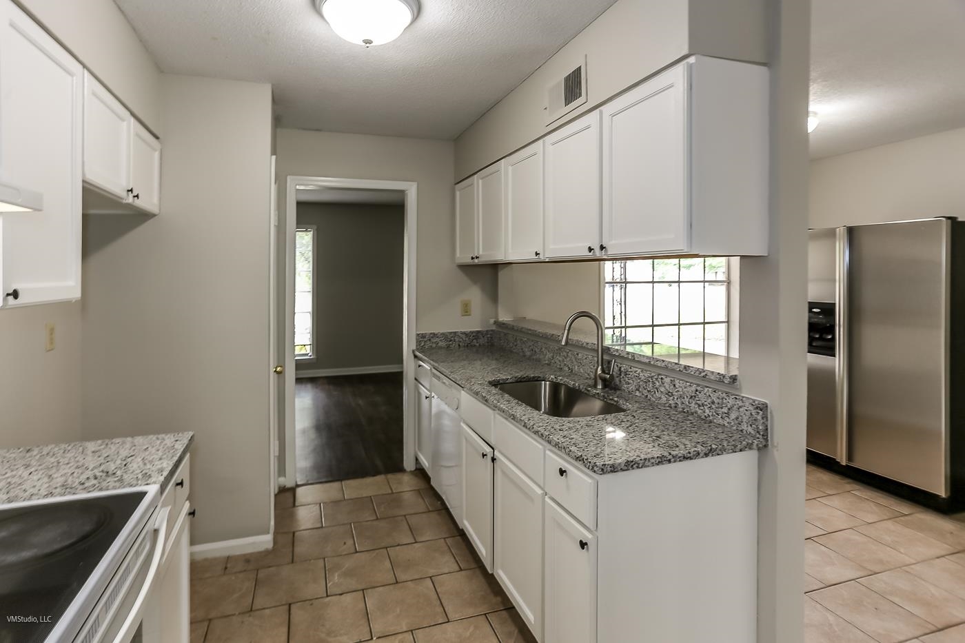 5217 Yale Road Memphis, TN 38134 - Photo 8 of 30 Kitchen with stainless steel fridge, sink, light tile patterned floors, and white cabinets