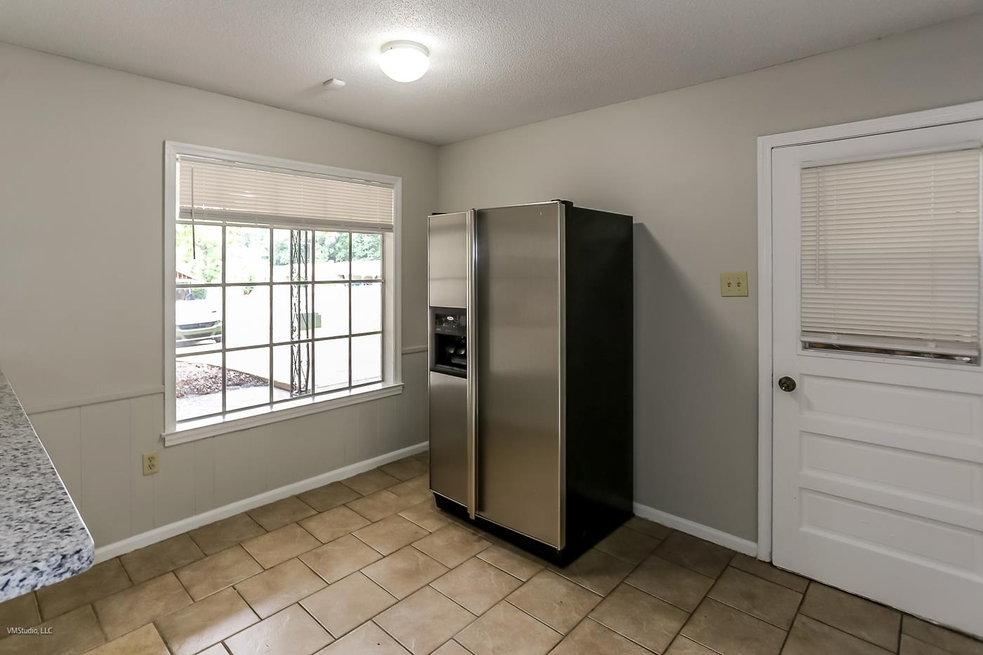 5217 Yale Road Memphis, TN 38134 - Photo 10 of 30 Kitchen featuring a textured ceiling, light tile patterned floors, and stainless steel fridge with ice dispenser