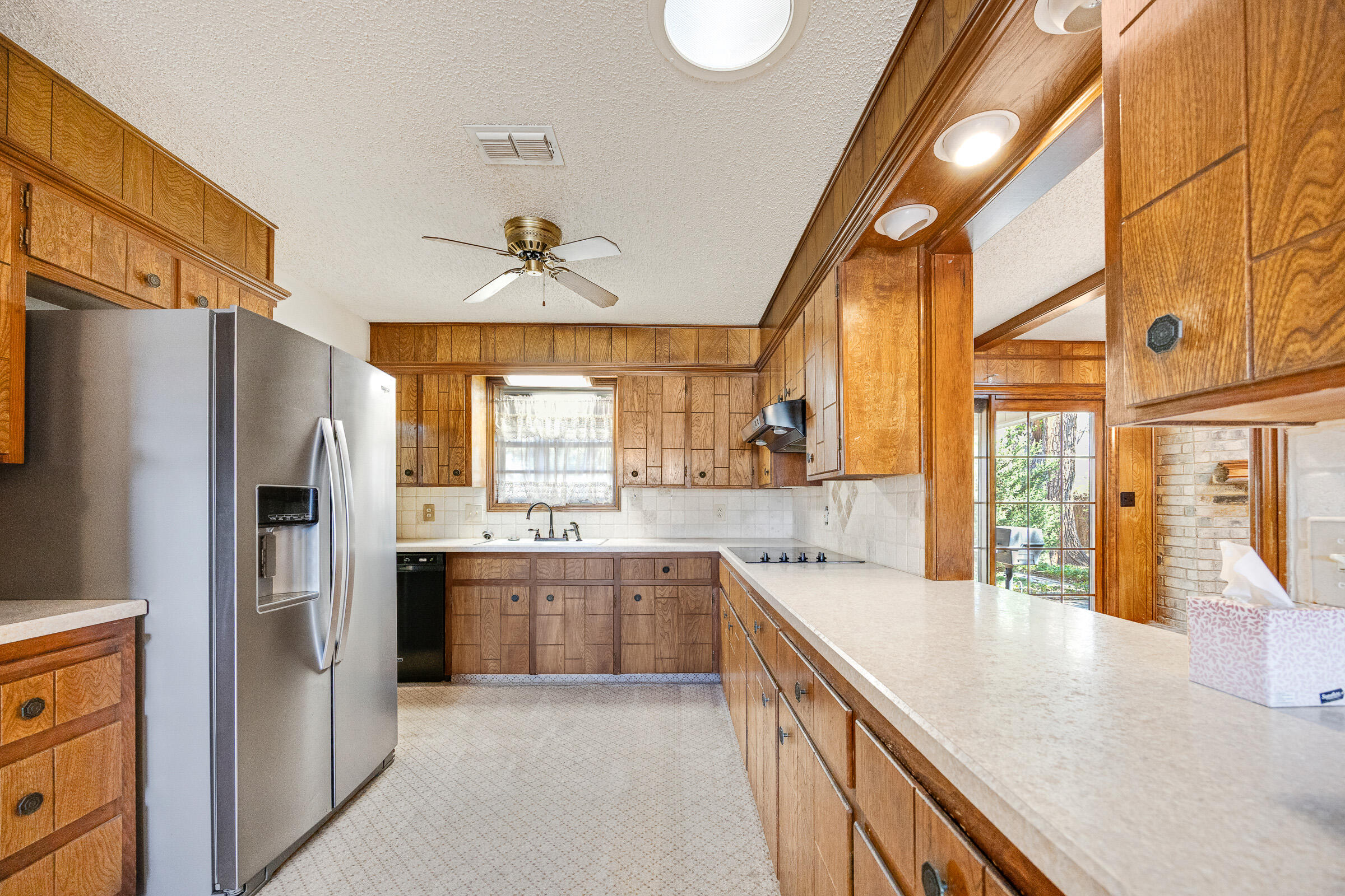 4416 62nd Street Lubbock, TX 79414 - Photo 13 of 70 a large kitchen with stainless steel appliances granite countertop a refrigerator a sink dishwasher a stove and white countertops with wooden floor