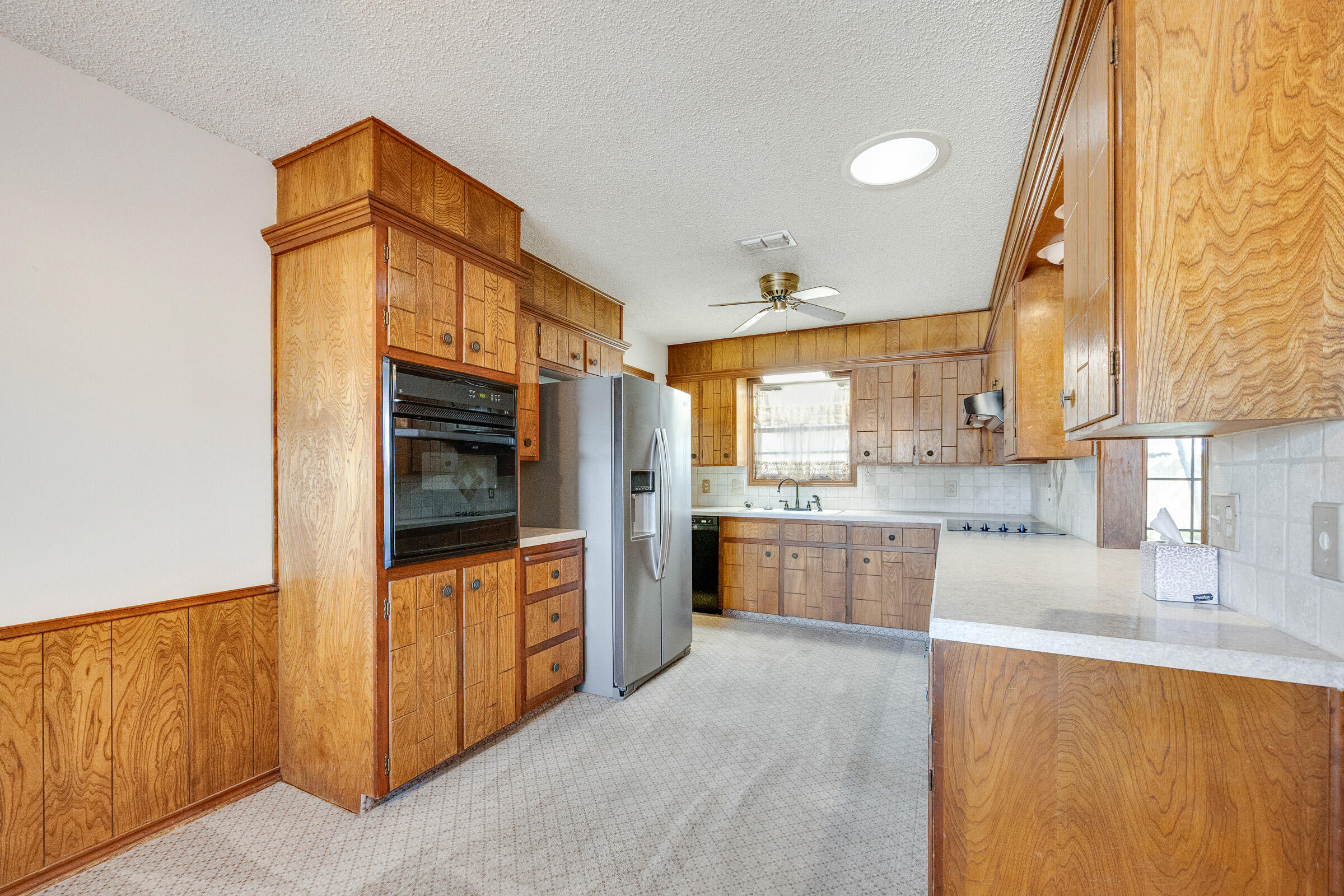 4416 62nd Street Lubbock, TX 79414 - Photo 14 of 70 a kitchen with granite countertop a refrigerator and a stove top oven