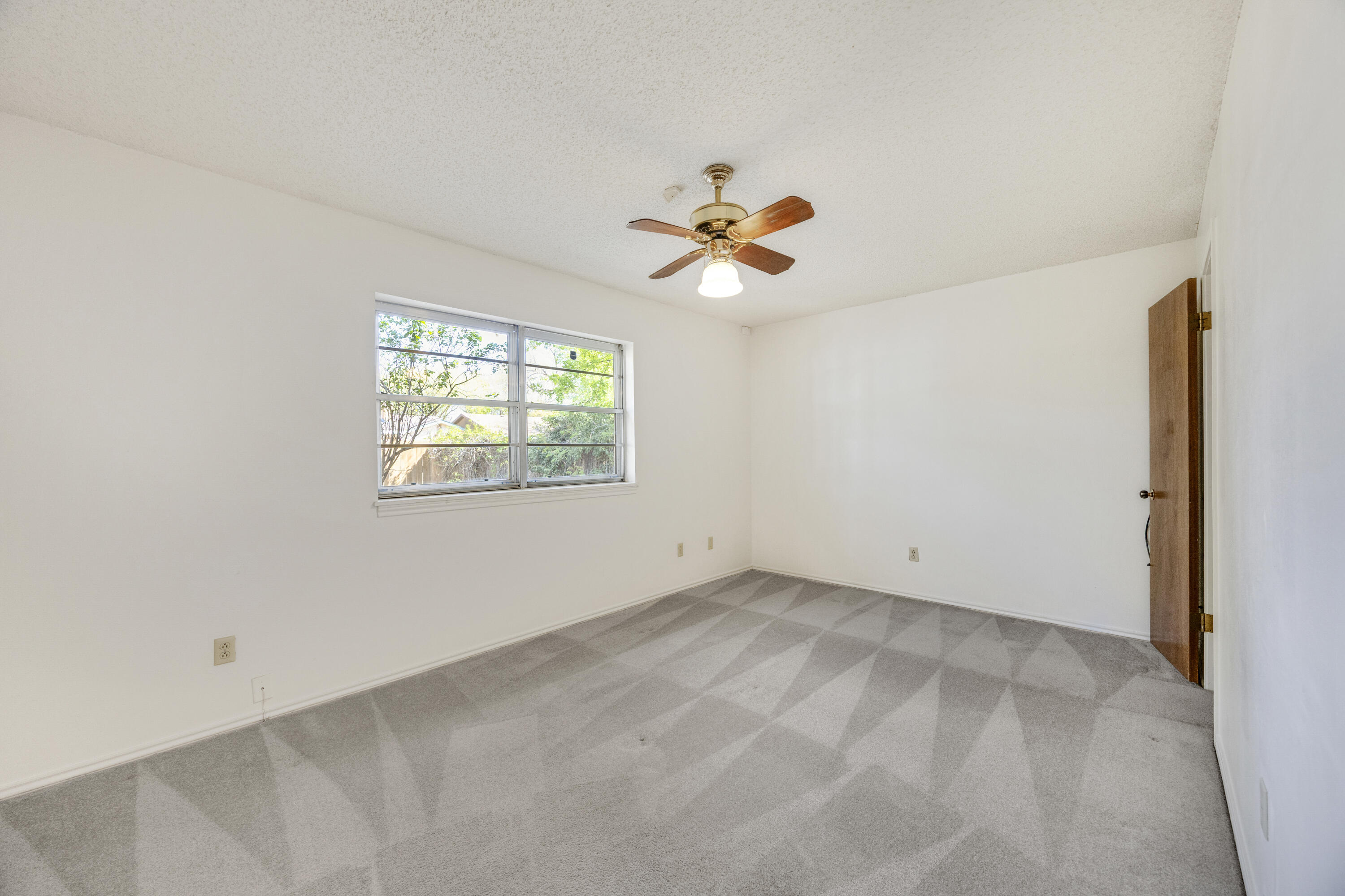 4416 62nd Street Lubbock, TX 79414 - Photo 21 of 70 an empty room with windows and a chandelier fan
