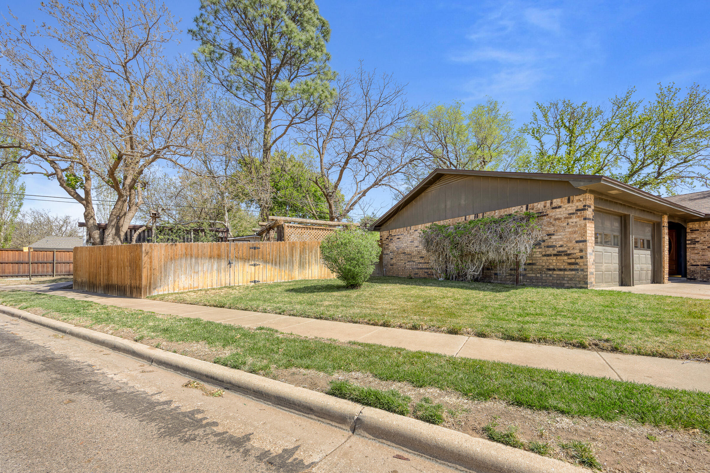 4416 62nd Street Lubbock, TX 79414 - Photo 6 of 70 a view of a yard in front of a house with large trees