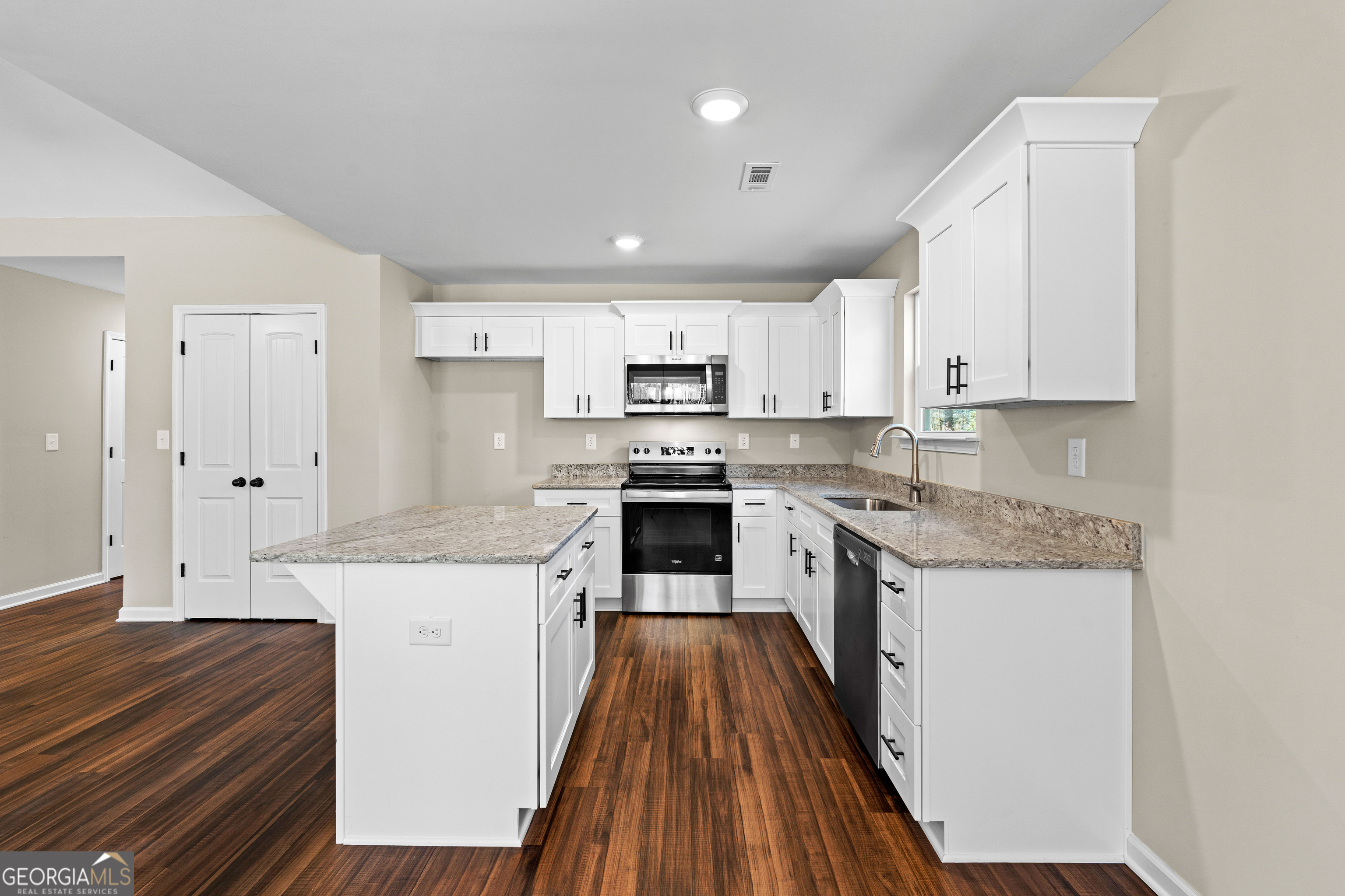 500 Todd Road Greenville, GA 30222 - Photo 13 of 47 a kitchen with granite countertop white cabinets a sink and wooden floor