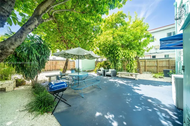 a view of a backyard with table and chairs under an umbrella