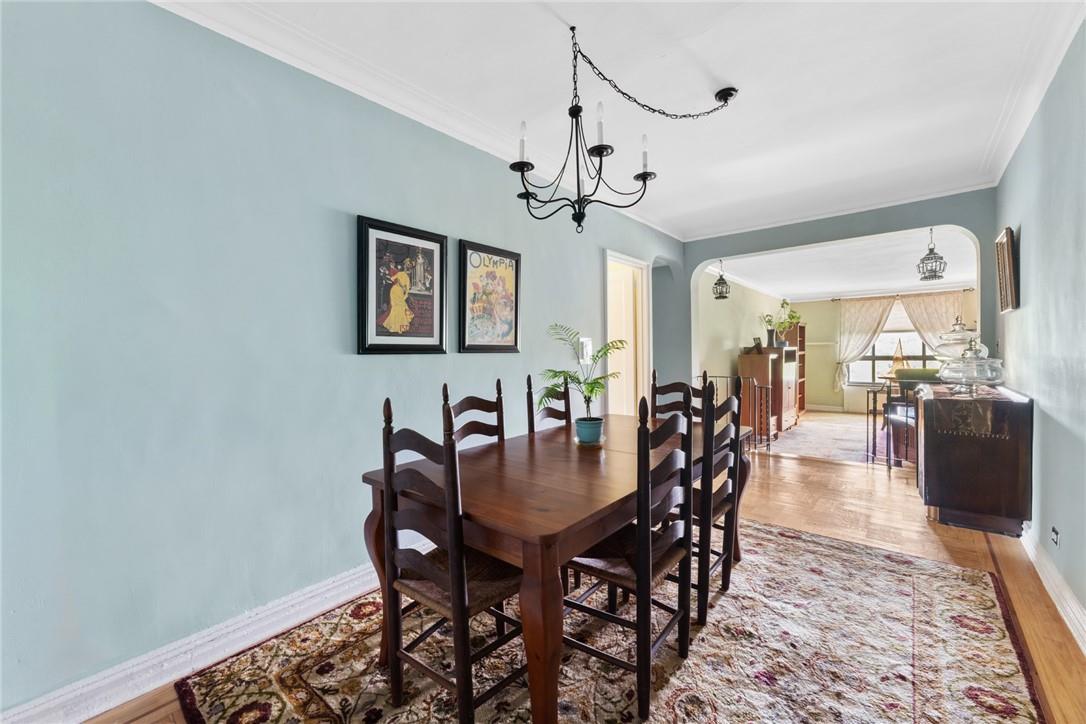 4445 Post Road, Unit 7D Bronx, NY 10471 - Photo 4 of 13 Dining room with a notable chandelier, light hardwood / wood-style flooring, and ornamental molding