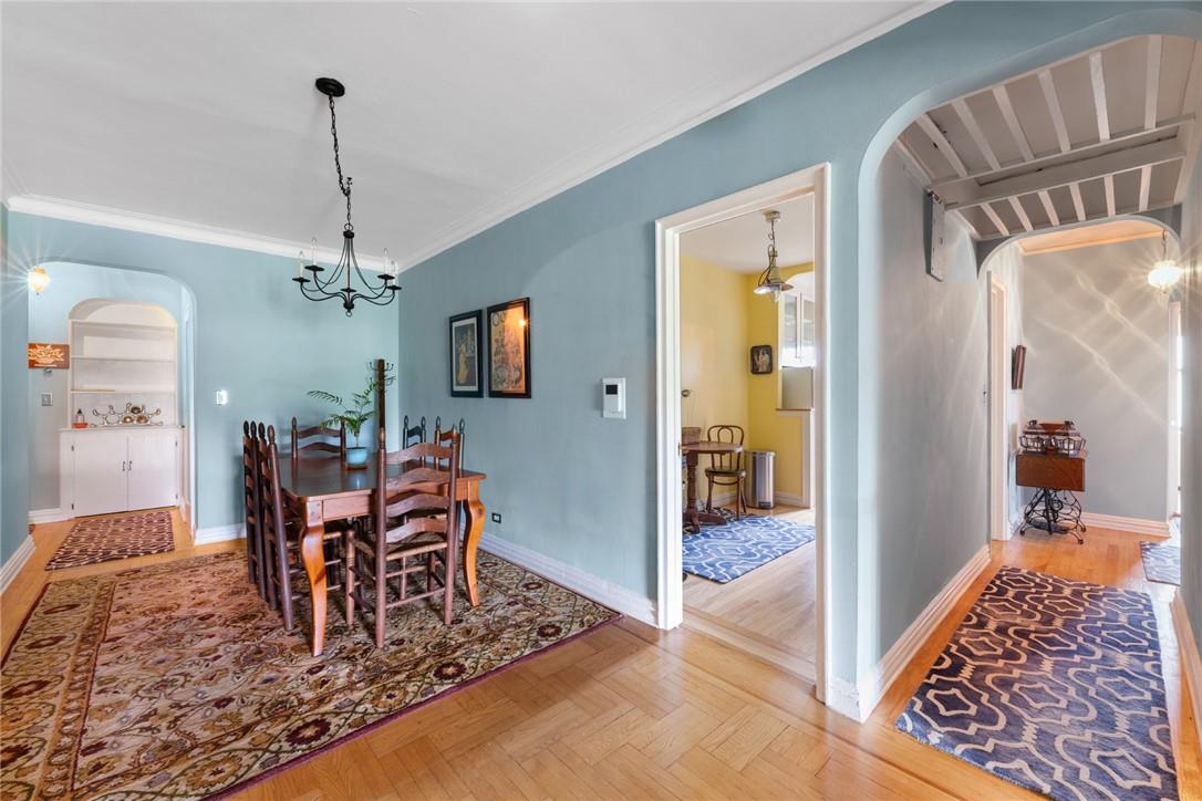 4445 Post Road, Unit 7D Bronx, NY 10471 - Photo 5 of 13 Dining room featuring light parquet floors, crown molding, and a chandelier