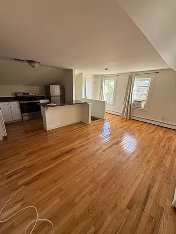 a view of a living room and kitchen with wooden floor