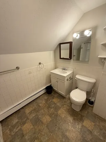 a bathroom with a toilet sink and mirror