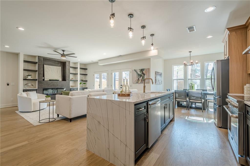 5249 Moon Road Powder Springs, GA 30127 - Photo 2 of 43 a large kitchen with kitchen island a large counter top space a sink stainless steel appliances and cabinets