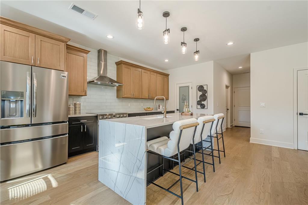 5249 Moon Road Powder Springs, GA 30127 - Photo 26 of 43 a kitchen with stainless steel appliances granite countertop a refrigerator a sink dishwasher a stove and white cabinets with wooden floor
