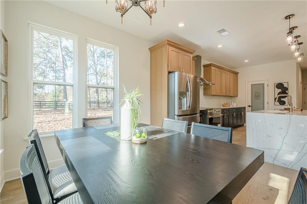 5249 Moon Road Powder Springs, GA 30127 - Photo 29 of 43 a living room with kitchen island granite countertop wooden floor a large window and stainless steel appliances