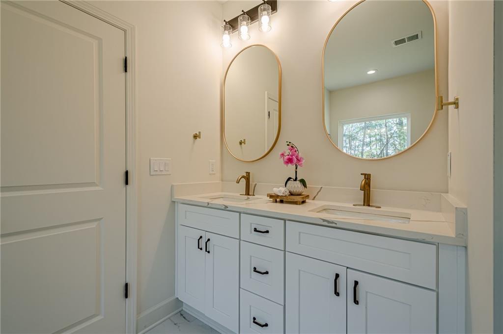 5249 Moon Road Powder Springs, GA 30127 - Photo 32 of 43 a bathroom with a granite countertop sink a mirror and a shower