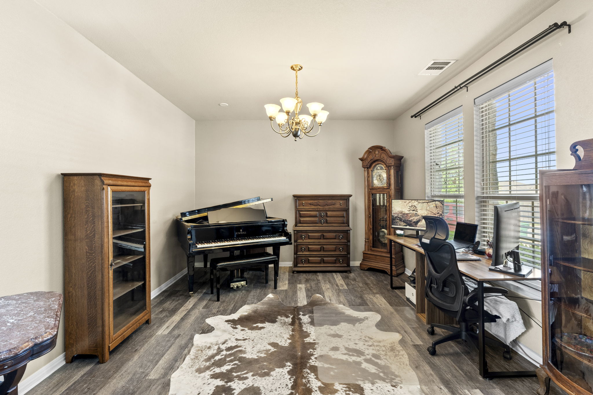 227 Sandstone Trail Buda, TX 78610 - Photo 5 of 33 Spacious room featuring wood-finish flooring, ample natural light from multiple windows, crown molding, and a chandelier lighting fixture