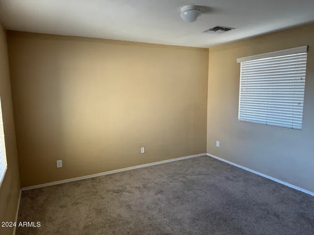 a view of an empty room with closet and wooden floor