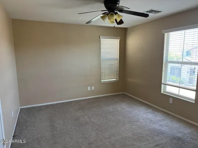 an empty room with windows and fan