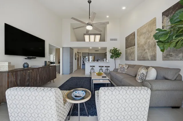 a living room with furniture a flat screen tv and a large window