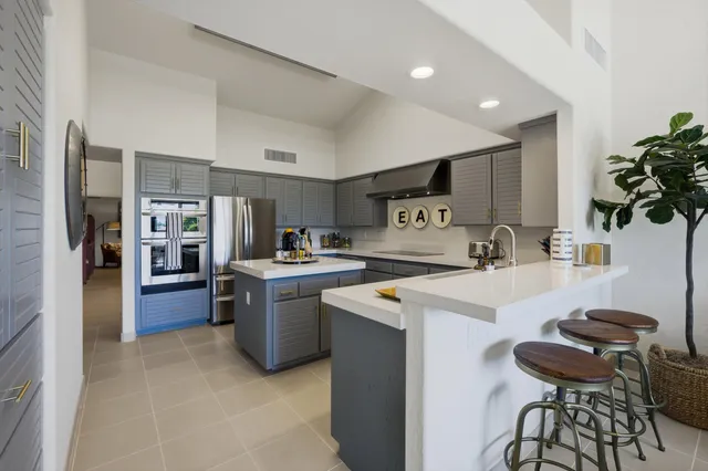 a kitchen with a sink a stove and chairs