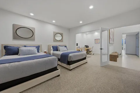 a spacious bedroom with two beds and a chandelier