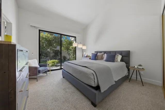 a bedroom with a bed couch and a large window