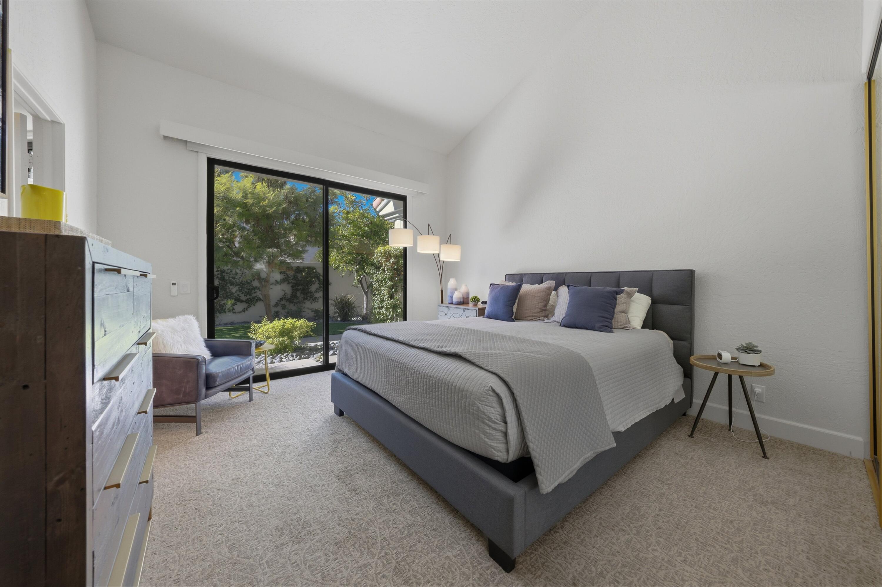 54672 Inverness Way La Quinta, CA 92253 - Photo 28 of 49 a bedroom with a bed couch and a large window