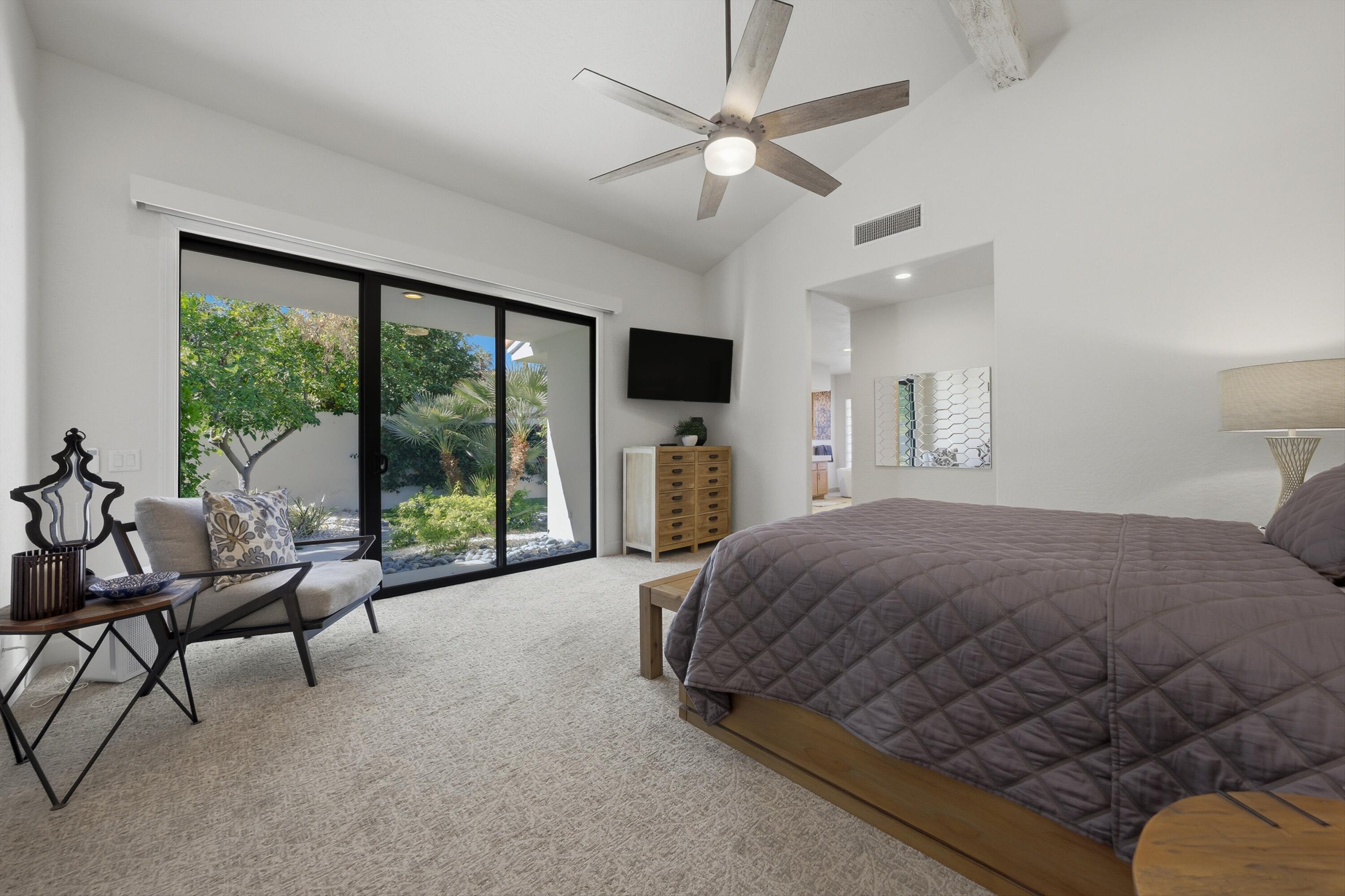 54672 Inverness Way La Quinta, CA 92253 - Photo 31 of 49 a spacious bedroom with a bed couch and a large window