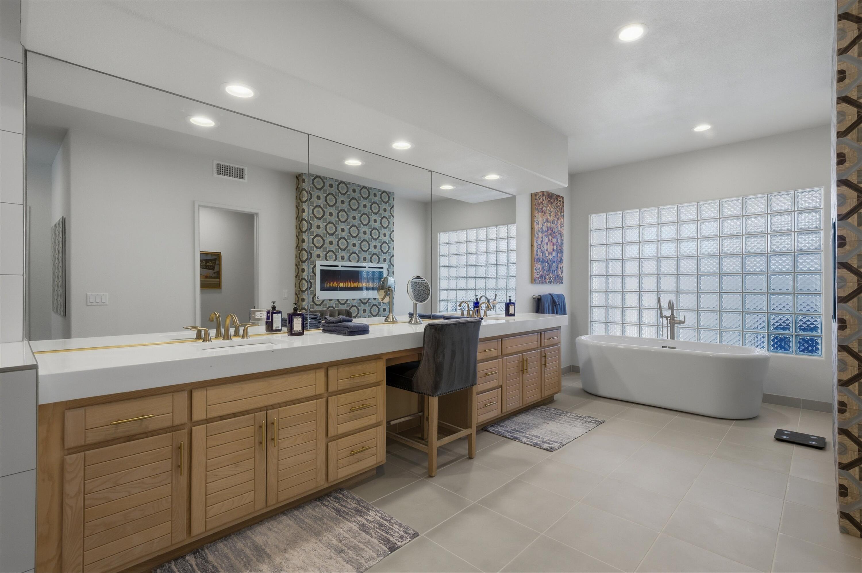 54672 Inverness Way La Quinta, CA 92253 - Photo 33 of 49 a large bathroom with a double vanity sink a large mirror and a bathtub