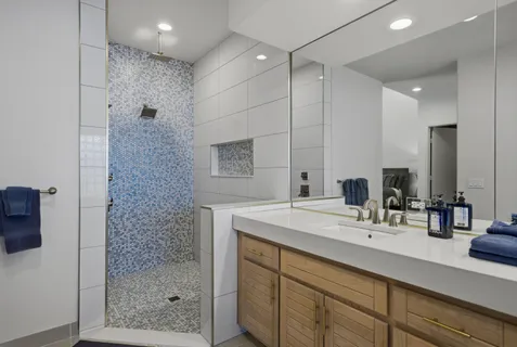 a bathroom with a shower sink and mirror