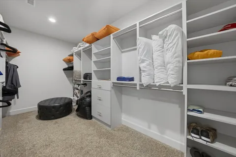 a view of walk in closet with clothes and shoes