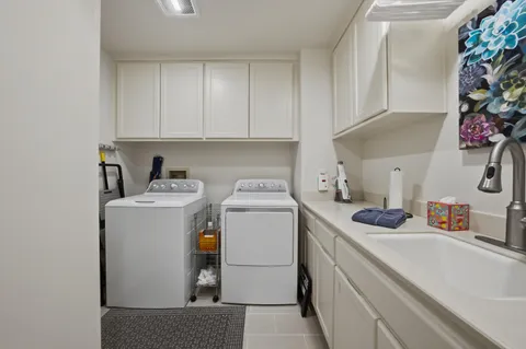 a utility room with sink dryer and washer