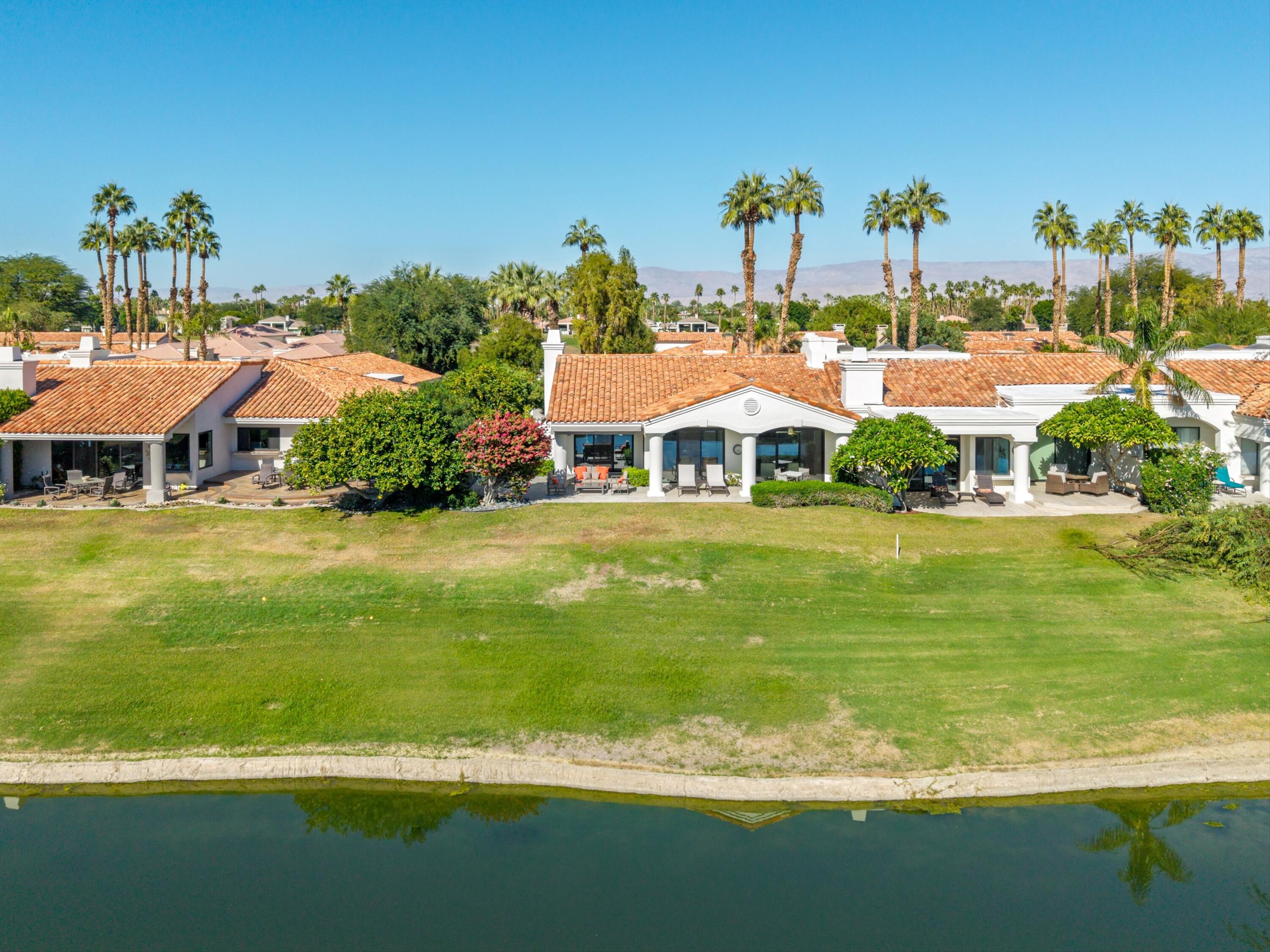 54672 Inverness Way La Quinta, CA 92253 - Photo 39 of 49 a front view of a house with a garden and lake view