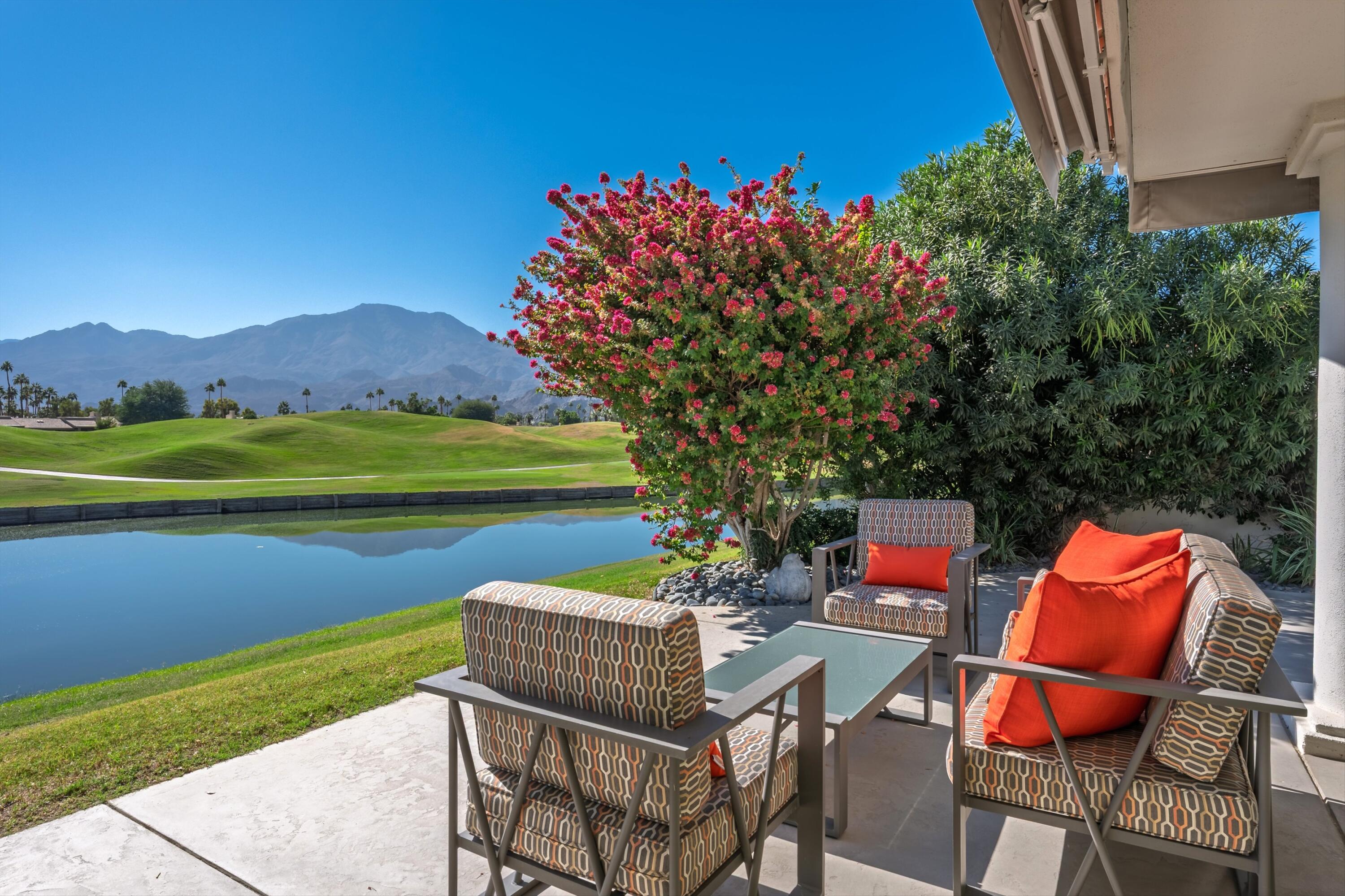 54672 Inverness Way La Quinta, CA 92253 - Photo 47 of 49 a view of a chairs and table in patio with a lake view