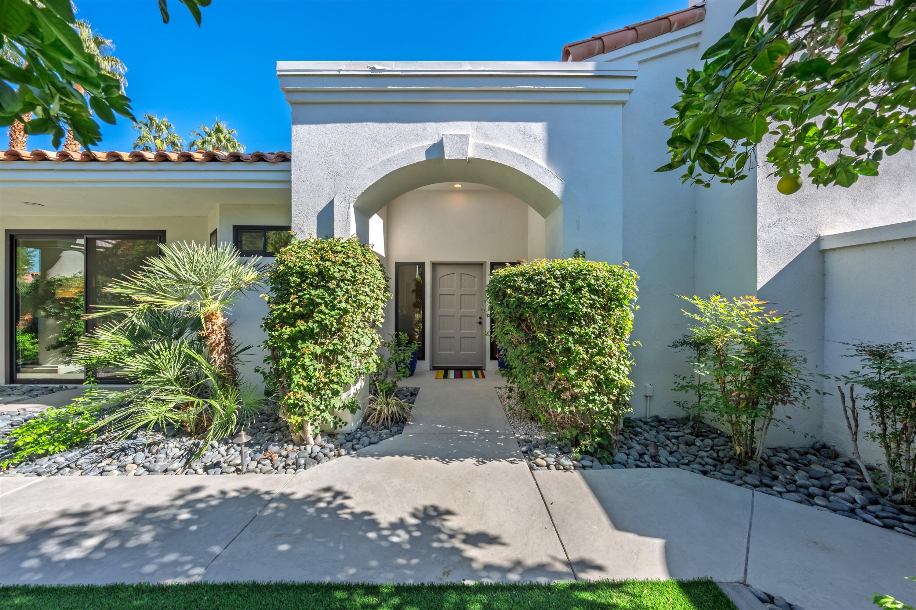 54672 Inverness Way La Quinta, CA 92253 - Photo 7 of 49 a front view of a house with lots of green space