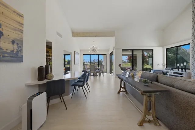 a living room with furniture a dining table and a large window