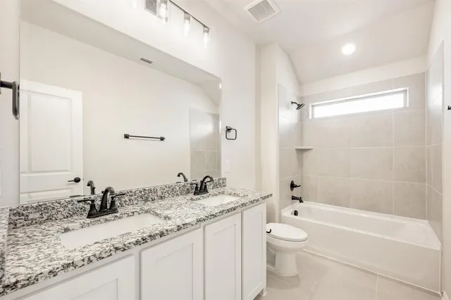a bathroom with a granite countertop sink toilet mirror and bathtub