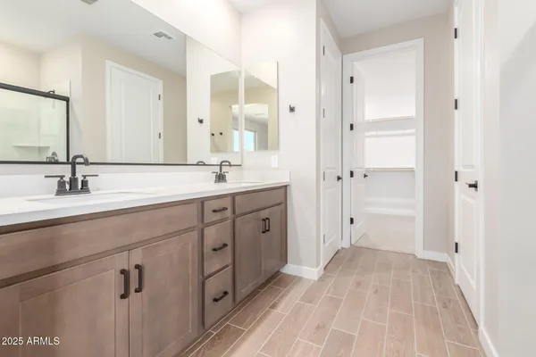 a spacious bathroom with a double vanity sink a mirror and a shower